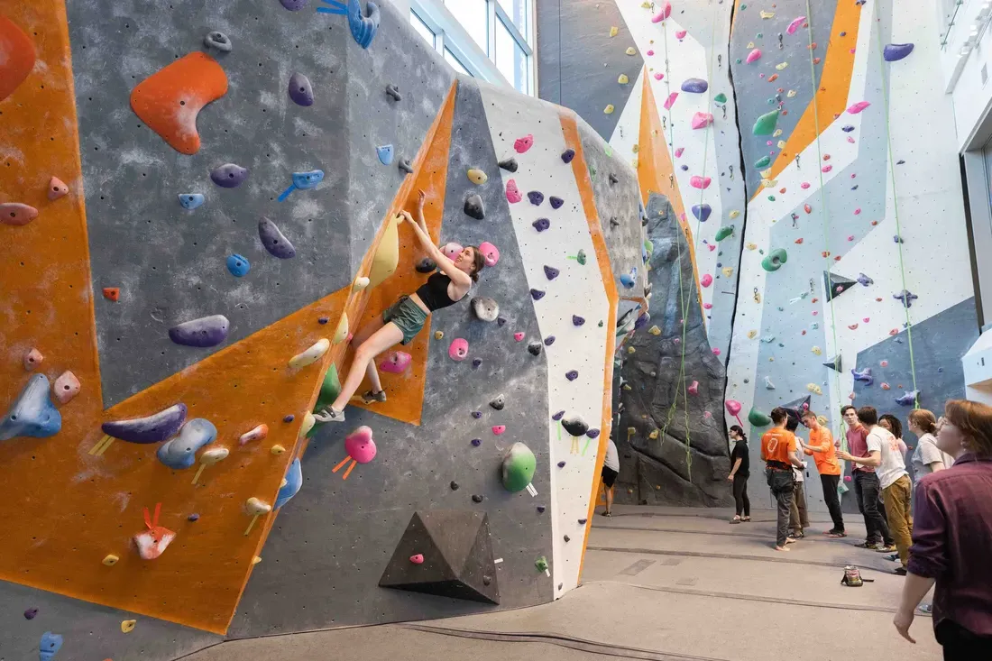 Students enjoy the indoor rock-climbing wall at the Barnes Center.